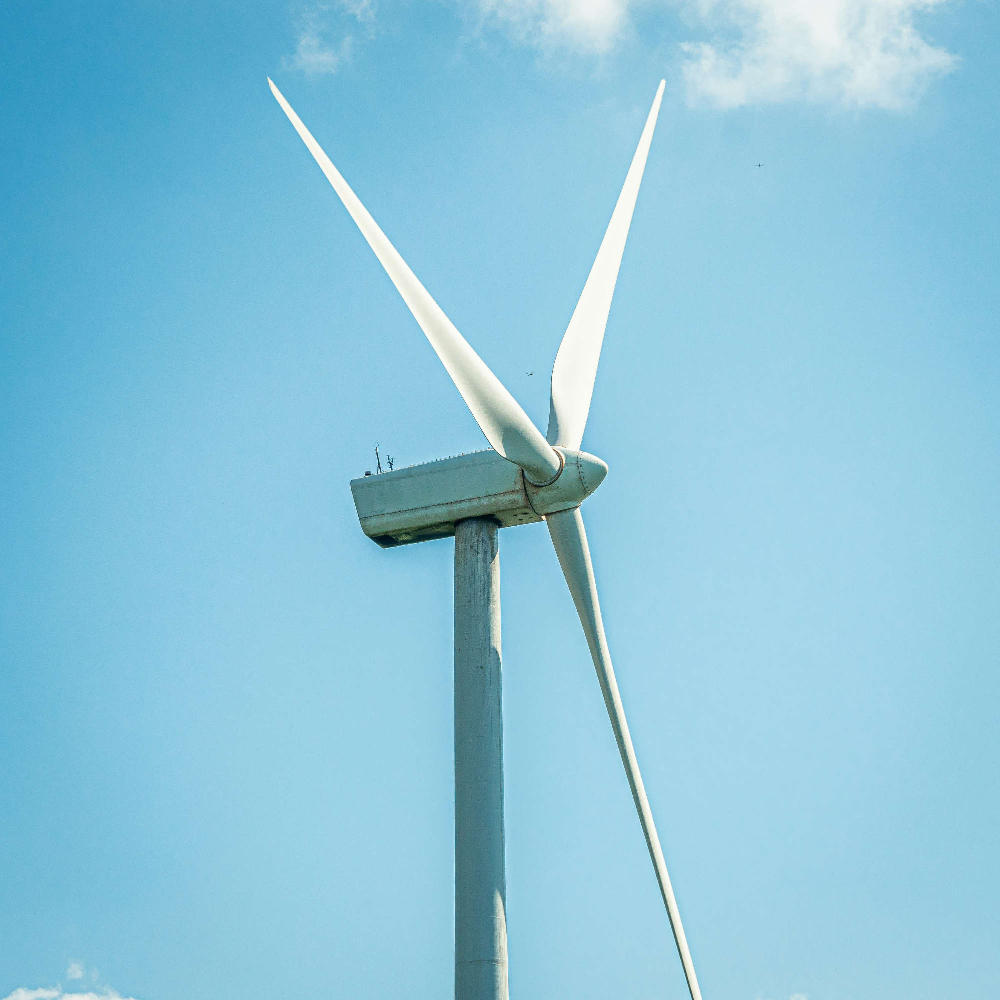 A close up of a wind turbine against a clear sky